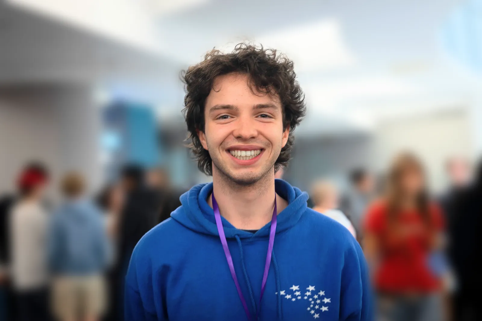 Isaac McAreavey smiling, wearing a blue hoodie and lanyard